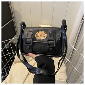 Détail du sac bandoulière en cuir PU noir avec écusson ours mignon et boucles décoratives