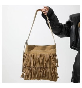Detail of khaki tassel shoulder bag with long fringe and vintage bohemian suede texture