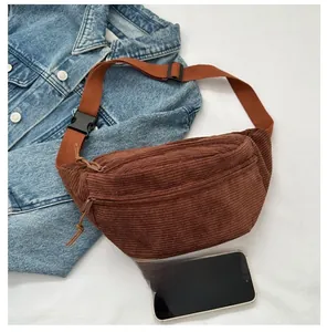 Brown corduroy crossbody bag size comparison with smartphone and denim jacket