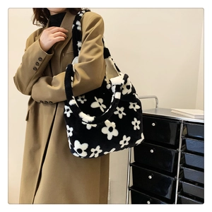 Detail shot of plush black and white floral shoulder bag showing soft faux fur texture