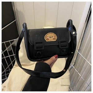 Détail du sac bandoulière en cuir PU noir avec un joli écusson brodé de chiot en peluche