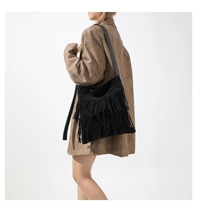 Detailed view of a vintage black fringe tote bag in soft suede fabric on model