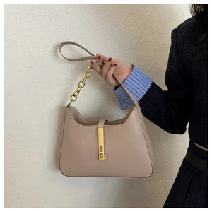 Gros plan d'un sac bandoulière en cuir marron avec une chaîne dorée et boucle chic