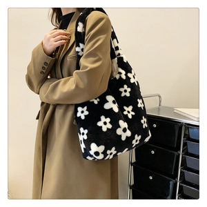 Detail of plush flower tote bag with soft faux fur texture shown on a beige trench coat