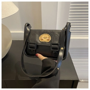 Détail du mini sac bandoulière en cuir PU noir avec écusson dessin animé et boucles à rabat