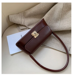 Détail du sac à main en similicuir rouge foncé avec un fermoir doré rectangulaire rétro