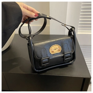 Détail d'un mini sac bandoulière en cuir PU noir avec broderie de chiot jaune
