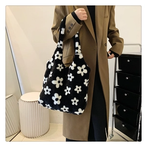 Detailed close-up of soft plush tote bag featuring black and white daisy floral patterns
