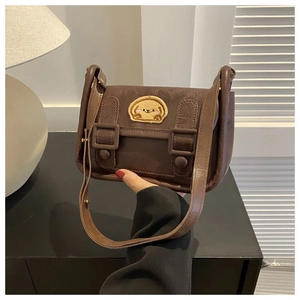 Détail d'un sac bandoulière en similicuir marron avec broderie chien et boucles