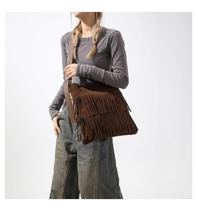 Close-up of brown suede shoulder bag featuring bohemian double-layer fringe and wide strap