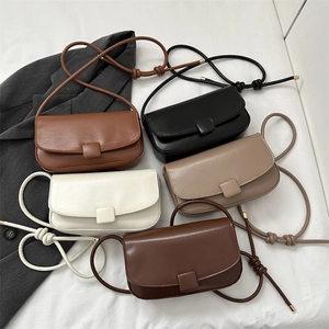 Minimalist square flap crossbody bag in five elegant colors on a textured white surface
