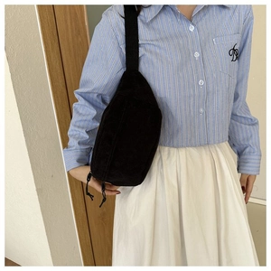 Detail of black corduroy crescent crossbody bag showing textured fabric and casual fit