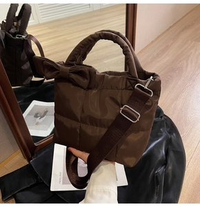 Détail du sac matelassé marron foncé avec un grand nœud et une bandoulière réglable