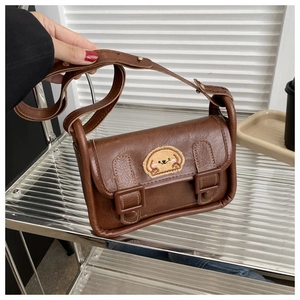 Détail du sac à bandoulière marron en cuir PU avec patch mignon et deux boucles ardillon