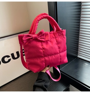 Gros plan du sac cabas matelassé rose vif avec un grand nœud et des poignées rembourrées