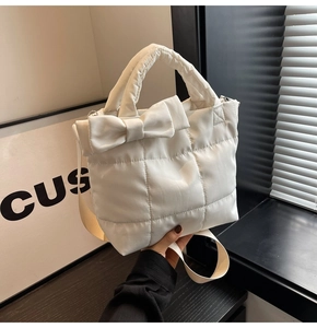 Vue détaillée du sac matelassé blanc crème avec n&oelig;ud et grandes surpiqûres