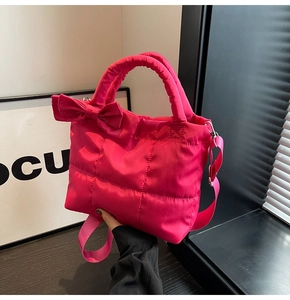 Détail du sac cabas matelassé rose rouge avec nœud décoratif et texture rembourrée