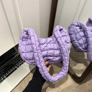 Purple quilted cloud bag with puffy texture and thick handle shown in hand