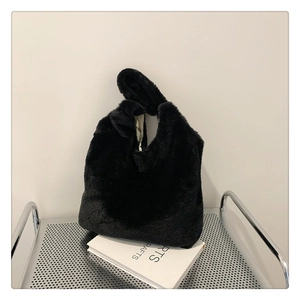 Detailed close-up of fluffy black faux fur texture and handle of this soft plush tote bag