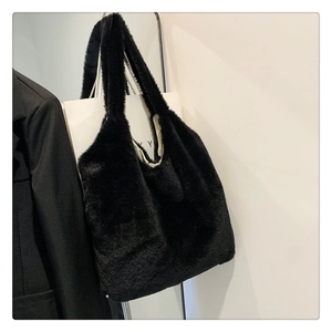 Close-up of the plush black faux fur texture and beige lining of this large tote bag