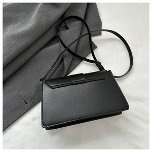 Minimalist black PU leather rectangular crossbody bag on premium fabric backdrop