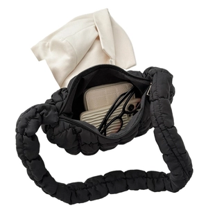 Overhead view of black quilted puffer tote bag filled with everyday essentials