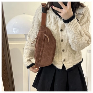 Detailed view of brown corduroy crossbody bag with adjustable strap and plastic buckle