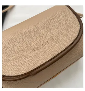 Detail of beige lychee leather bag with contrast edging and Fashion & Bags embossing