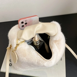 Chic cream faux fur handbag with leather handle and heart charm showing interior capacity