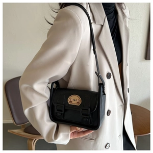 Modèle portant un sac bandoulière noir avec broderie cartoon et doubles sangles décoratives
