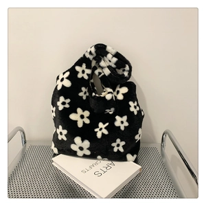 Detailed view of plush tote bag featuring soft faux fur with black and white floral pattern