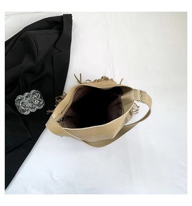 Macro view of khaki tassel tote bag interior showing spacious lining and shoulder strap