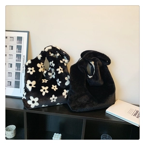 Detail of plush faux fur tote bags in black and floral patterns with soft texture