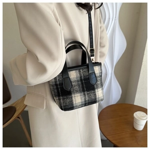 Elegante borsa tote in tela a scacchi bianca e nera abbinata a un blazer casual crema