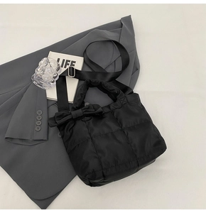 Vue détaillée du sac cabas matelassé noir avec nœud décoratif et bandoulière réglable