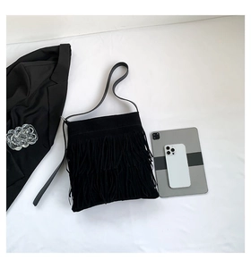 Detail of vintage black tote bag featuring tiered fringes and soft suede texture