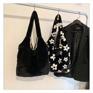 Detailed view of plush tote bags in solid black and floral patterns with soft texture