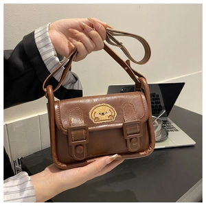 Détail d'un sac bandoulière en similicuir marron foncé avec broderie chiot et rabat rétro