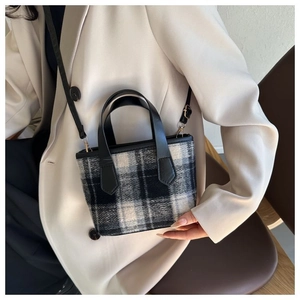 Modello con mini borsa a tracolla in tweed a quadri con finiture in pelle nera e tracolla