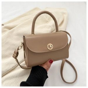 Detailed view of vintage crossbody bag with gold round clasp and leather top handle