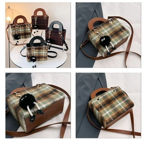 Close-up of wool plaid pattern texture and brown leather side detailing of the handbag