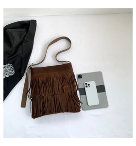 Detail shot of vintage brown suede tote bag featuring three layers of stylish long fringes