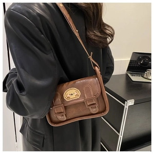 Vue détaillée d'un sac bandoulière vintage en cuir marron avec broderie de chiot mignon