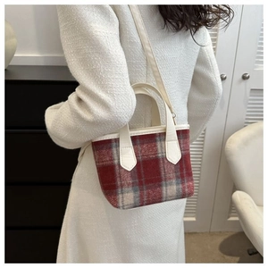 Borsa a tracolla a quadretti abbinata a un cappotto in tweed bianco in interni moderni