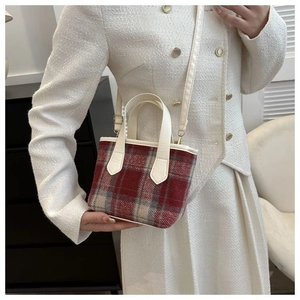 Dettaglio della borsa a tracolla in tweed rosso e bianco con manico avorio e oro hardware