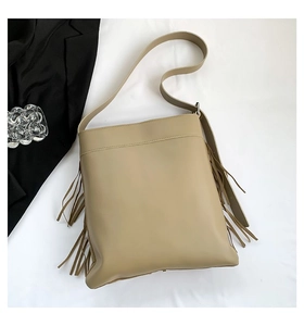 Detailed view of khaki tote bag with elegant tassel fringe and wide shoulder strap