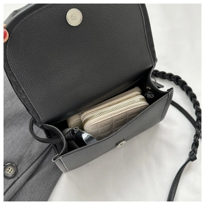 Internal view of black pebble leather crossbody bag with woven strap and wallet
