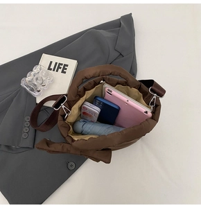 Détail du sac matelassé marron montrant sa grande capacité pour tablette et objets