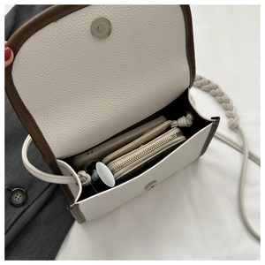 Interior view showing the capacity of the white leather crossbody bag with items