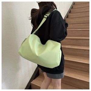Detalle de bolso bandolera de nailon verde claro con correa ajustable y uso diario práctico